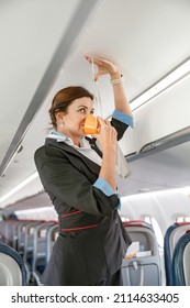 Stewardess Demonstrating How To Use Oxygen Mask In Aircraft