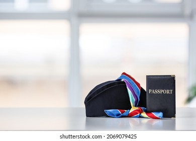 Stewardess Hat With Passport And Scarf On Table Indoors