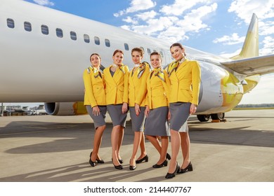 Stewardesses standing near passenger airplane at airport - Shutterstock ID 2144407767