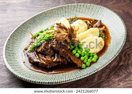 Stewed beef veal cheeks with mashed potatoes on plate