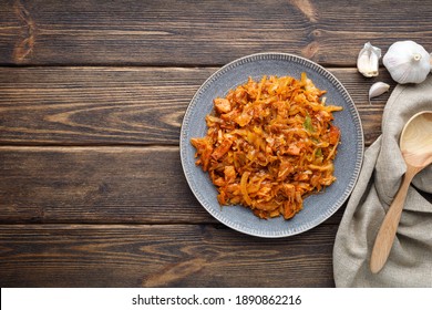Stewed or braised cabbage in a plate on a wooden table.