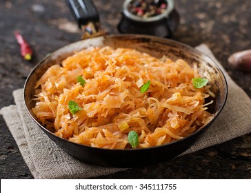 Stewed cabbage on the old wooden background in rustic style