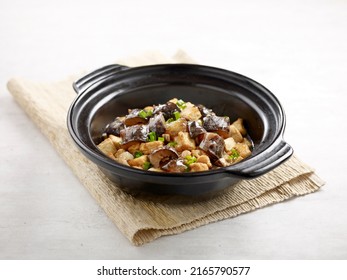 Stewed Diced Sea Cucumber With Tofu In Casserole Served In A Dish Isolated On Wooden Board Side View On Grey Background