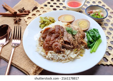 Stewed Pork leg and egg over rice at close up view on wood table - ( Thai - Chinese food called “ Khao Kha Moo”) - Shutterstock ID 2161178817
