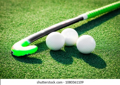 
stick and balls for playing field hockey on the grass background