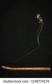 Stick Holder and Incense Stick with Smoke on Black Background - Shutterstock ID 1198774174
