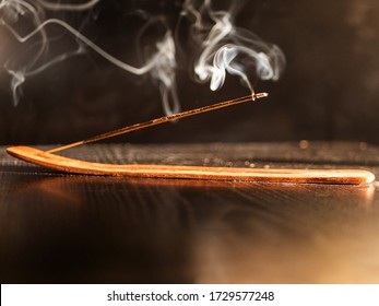 Stick Holder and Incense Stick with Smoke on Black Background. Pure relaxation theme. - Powered by Shutterstock