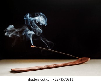 Stick Holder and Incense Stick with Smoke on Black Background. Pure relaxation theme. - Powered by Shutterstock