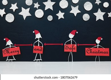 Stick Man Family Figure Wearing Santa Hat With Red Distance Marker And Merry And Safe Christmas Greeting Banner. Covid Holidays Celebration Concept.