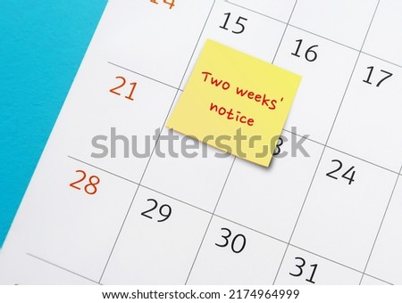 Stick note with handwritten remark and words - Two weeks' notice - on calendar , means employee courtesy to give employer time to prepare for resignation and hiring someone else