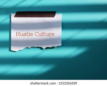 Stick note on blue background with text HUSTLE CULTURE - lifestyle where career has become frirst priority in life, state of constant overworking to the point where it becomes lifestyle