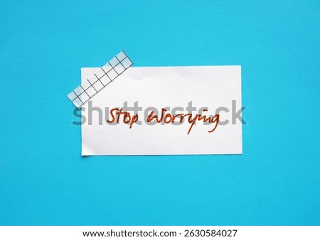 Stick note on blue background with text written STOP WORRYING - self talk to turn off anxious thoughts - to stay calm and look at life from less fearful perspective - reduce rumination