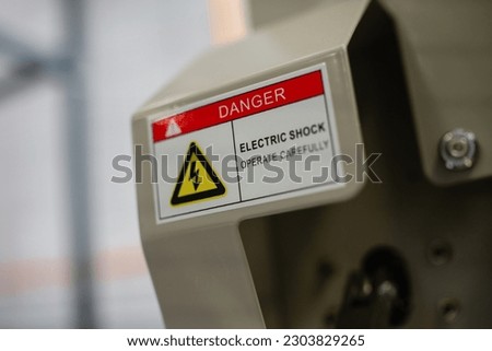 sticker with caution information on front panel of industrial machine