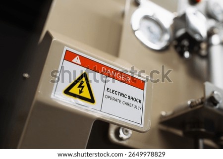 sticker with caution information on front panel of industrial machine