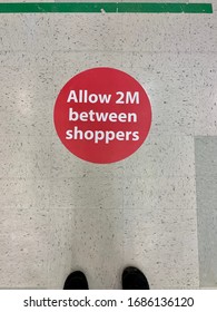 A Sticker On A Grocery Store Floor Asking Shoppers To Stay Two Metres Apart During The CoVid Pandemic 