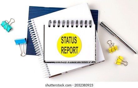 Sticker with STATUS REPORT text on the notebooks on white background - Shutterstock ID 2032383923
