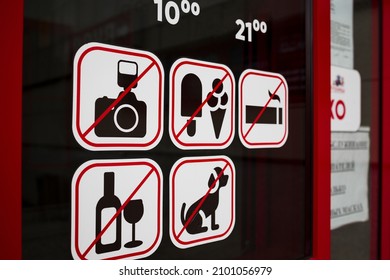 Stickers on the glass window near the door with prohibitions. symbols camera, food, ice cream, dog not allowed - Shutterstock ID 2101056979