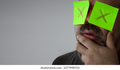 Stickers with painted crosses are glued to the eyes of a guy, a man is no looking. glued eyes. isolated white background. shocked face. unrecognizable person. forbidden information. - Shutterstock ID 2277998723