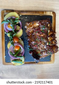 Sticky Glazed Short Ribs With Roast Potatoes And Vegetables. Asparagus , Onion And Tomatoes. Close-up On A Plate On The Table. Horizontal Top View From Above