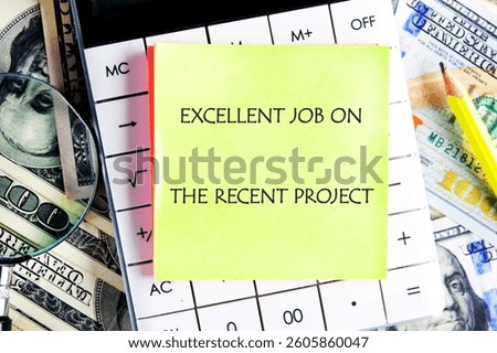 A sticky note with a commendation for a project is set on a calculator surrounded by cash, a magnifying glass, and a pencil in a workspace setting.