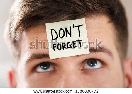 Sticky Note With Don't Forget Text Stuck On Forehead Of A Young Businessman