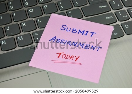 Sticky note with the handwritten text Submit Assignment Today placed on laptop keyboard. Selective focus. 
