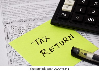 Sticky note with the handwritten text TAX RETURN placed on Income Tax Return filing form. Selective focus on the text.  - Shutterstock ID 2020498841