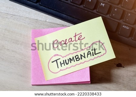 Sticky note with the memo Create Thumbnail on desk by the keyboard. 