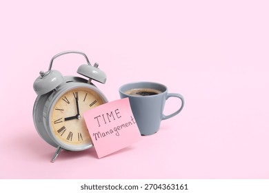 Sticky note with text TIME MANAGEMENT, alarm clock and cup of coffee on pink background