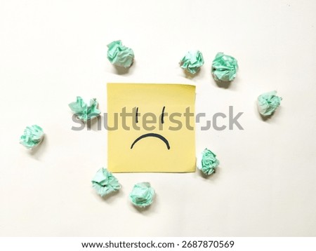 Sticky notes with sad face and scribbles among crumpled papers, symbolizing stress, fatigue, and the chaos of burnout
