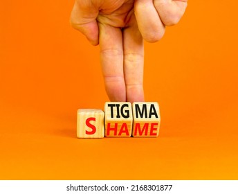 Stigma or shame symbol. Concept words Stigma or Shame on wooden cubes. Businessman hand. Beautiful orange table orange background. Business stigma or shame concept. Copy space.