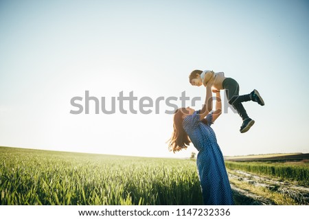 Stilish mother and handsome son having fun on the nature. Happy family concept. Beauty nature scene with family outdoor lifestyle. Happy family resting together. Happiness in family life. Mothers day.