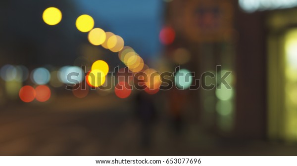 still blur background of night city with\
moving cars and walking people, wide\
photo
