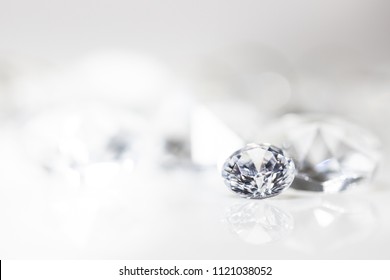 still with expensive cut diamonds in front of a white background, reflections on the ground. Lot of copyspace