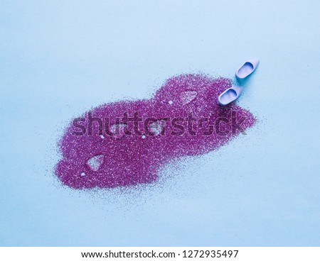 Still life of Barbie shoes leaving footprints in purple glitter