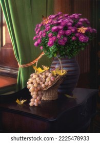 Still life with bouquet of purple chrysanthemums and grapes