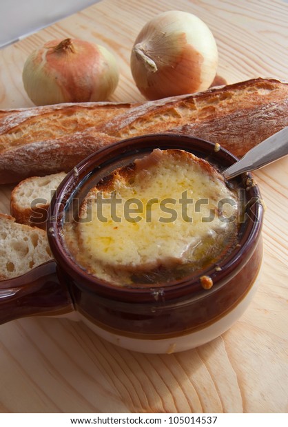Still life with bowl of french onion soup, bread
and onions