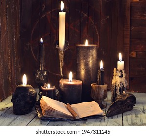 Still life with burning candles and open diary book on witch table.  Esoteric, gothic and occult background, Halloween mystic concept.