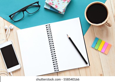 Still life, business, office supplies or education concept : top view image of open notebook with blank pages, mobile phone and coffee cup on wooden background, ready for adding or mock up