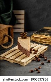 Still Life Of Chestnut Cake With Chocolate Mousse On A Dark Gray Table With Chocolate Pieces.