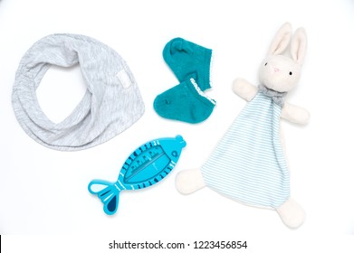 Still Life Of Children's Things. Plush Toy Gloves, Bath Thermometer, Socks, Bandana Drool Bib.