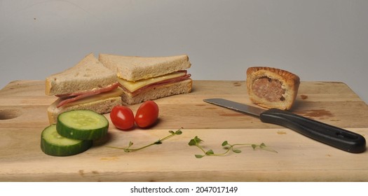 Still Life Chopping Board With Lunch On , Sandwhich , Fruit And Knife. Captured In Studio.