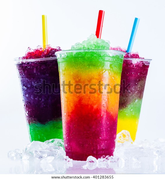 Still\
Life Close Up of Colorful Rainbow Layered Frozen Fruit Slush Drinks\
Arranged on Ice Covered White Surface in Plastic Take Away Cups\
with Drinking Straws - Trio of Refreshing\
Granitas