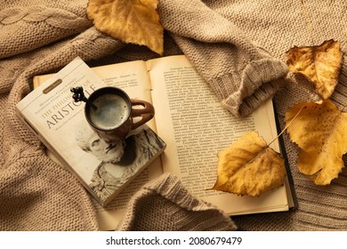 Still life coffee time. Autumn leaves , books and sweater. Book for Aristotle.  November 2021, Plovdiv , Bulgaria 