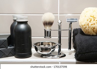 Still Life Detail View Of A Man Exclusive Grooming And Shaving Kit In A Luxury Home Or Hotel Bathroom With Soaps And Gels, Towels And A Sponge. Home Interior View.