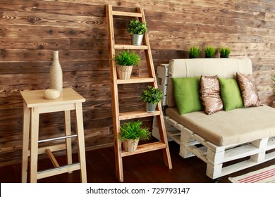 Still Life Details Of Cozy Home Interior In Rustic Style. Country Style Living Room With Wooden Stairs And Sofa With Green And Golden Pillows. Scandinavian Style Home Decor With Rustic Wooden Boards.