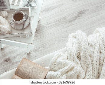 Still life details, cup of tea on retro vintage wooden tray on a coffee table in living room, top view point. Lazy winter weekend with a book on the sofa. - Shutterstock ID 321639926