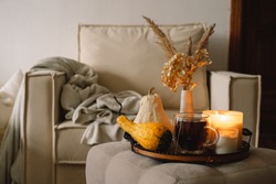 Still Life Details In Home Interior Of Living Room. Pumpkin And Cup Of Tea With Candles On A Serving Tray. Rest And Reading. Cozy Autumn 