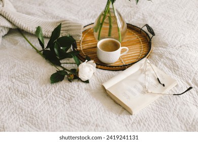 Still life details in home interior of living room. Open book with glasses, cup coffee and bouquet white pink peonies flowers. Read and rest. Cozy home - Powered by Shutterstock