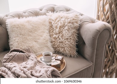 Still Life Details Of Nordic Living Room. Coffee And Sweater On The Sofa With Fur Cushions. Cozy Winter Scene In Scandinavian Interior.